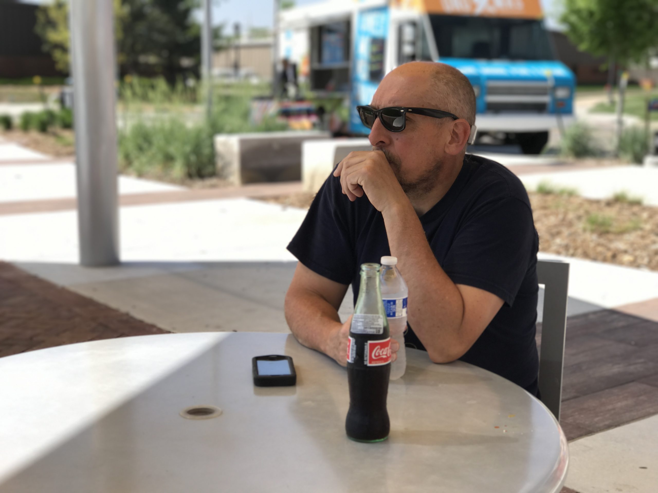 Artist Patrick Duegaw sitting at a picnic table on the WSU campus