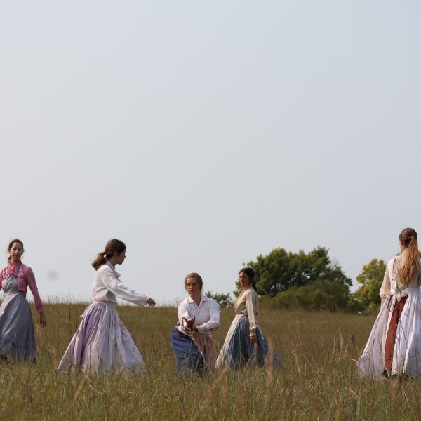 A group of people standing on top of a grass covered field