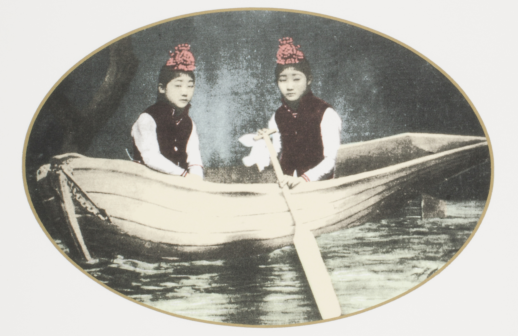 Two women in red hats are rowing a boat.